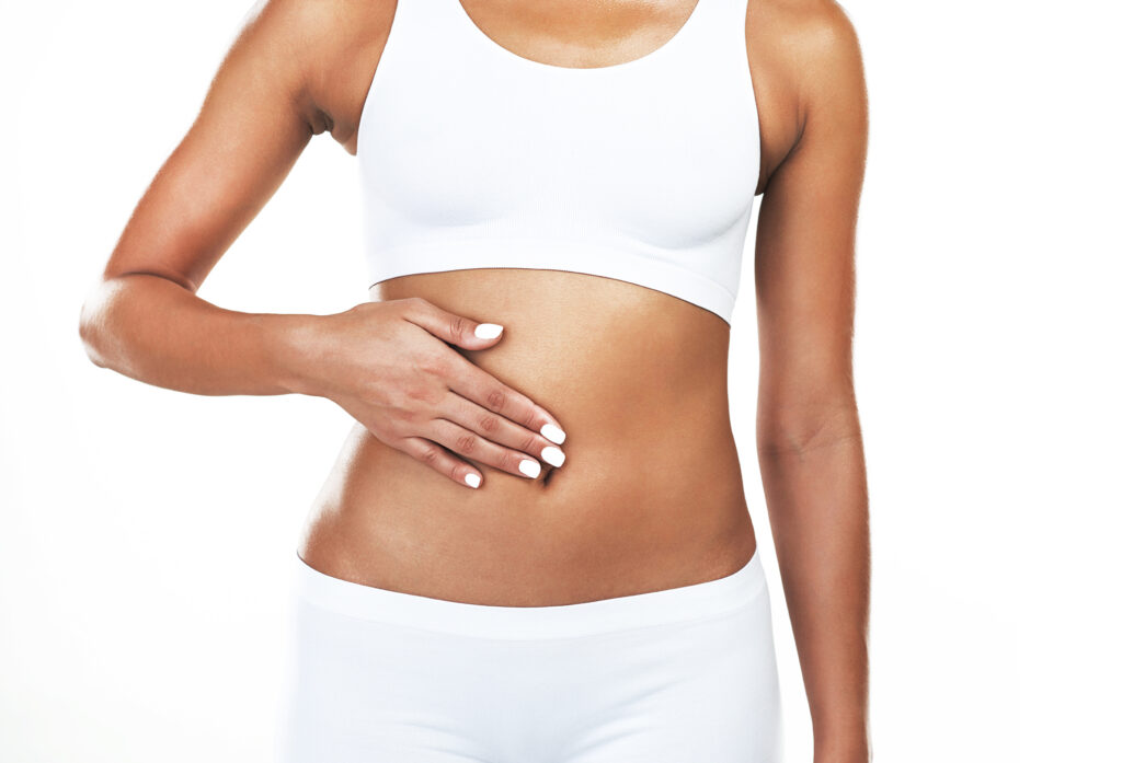Healthy eating will do wonders. Studio shot of an unrecognizable woman holding her tummy while standing against a white background.